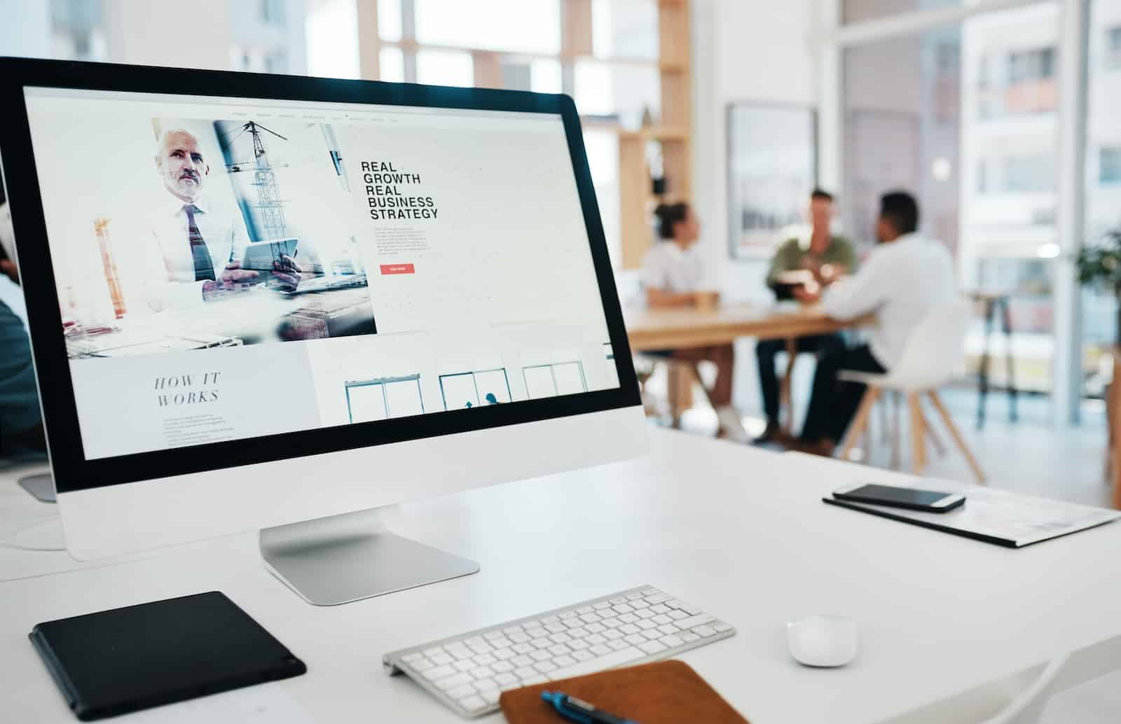 Foto aus einem Agentur-Setting in dem ein Agenturinhaber dem Kunden den Unterschied zwischen einer Werbeagentur und einer Webdesign-Agentur erklärt.